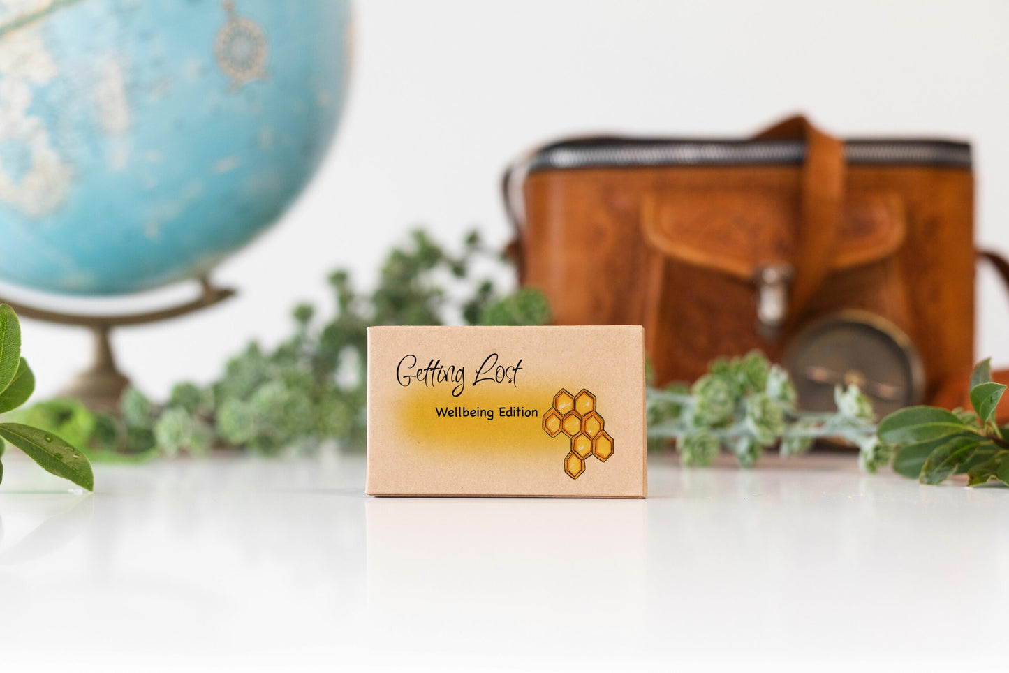 Getting Lost Travel Game - Wrapped Wellbeing Edition with a suitcase